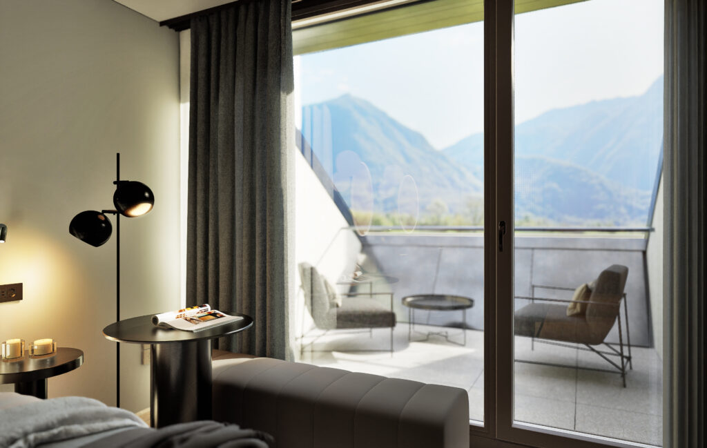 Sliding doors open from the Planika Room onto a balcony with two chairs and a view across the valley to the mountains